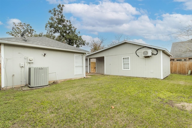 back of property featuring a lawn, cooling unit, and a wall mounted air conditioner