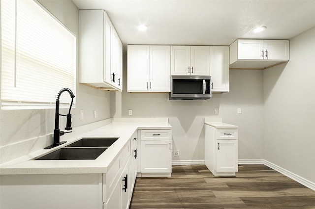 kitchen featuring dark hardwood / wood-style flooring, white cabinetry, and sink