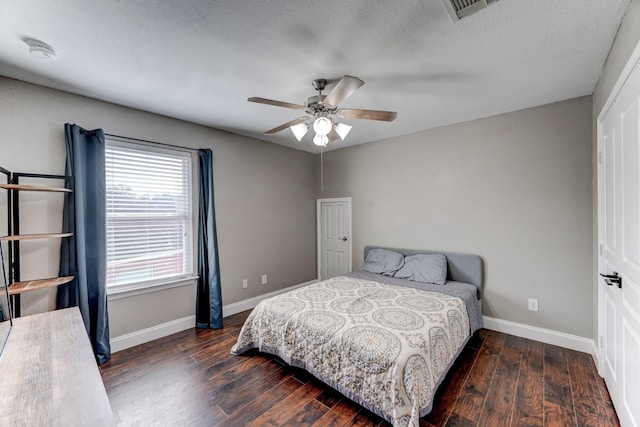 bedroom featuring a textured ceiling, dark hardwood / wood-style flooring, and ceiling fan