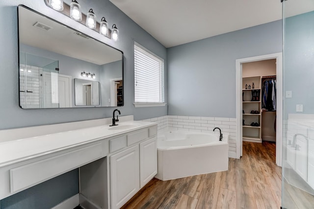 bathroom with separate shower and tub, vanity, and wood-type flooring