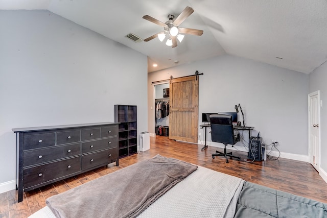 bedroom with ceiling fan, a barn door, a closet, and vaulted ceiling