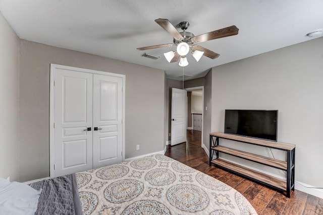 bedroom with ceiling fan, dark wood-type flooring, and a closet