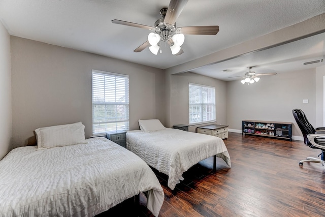 bedroom featuring ceiling fan, dark hardwood / wood-style flooring, and multiple windows