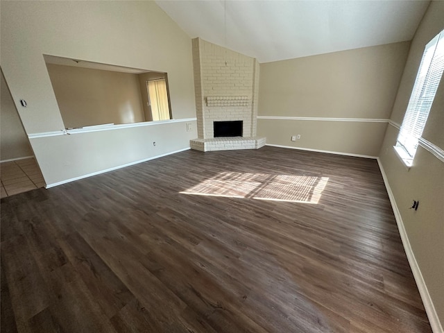 unfurnished living room with dark wood-type flooring, a fireplace, and vaulted ceiling