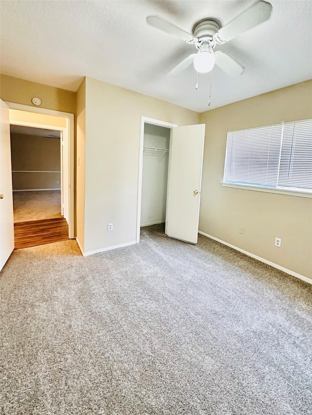 unfurnished bedroom featuring ceiling fan, a closet, and light colored carpet