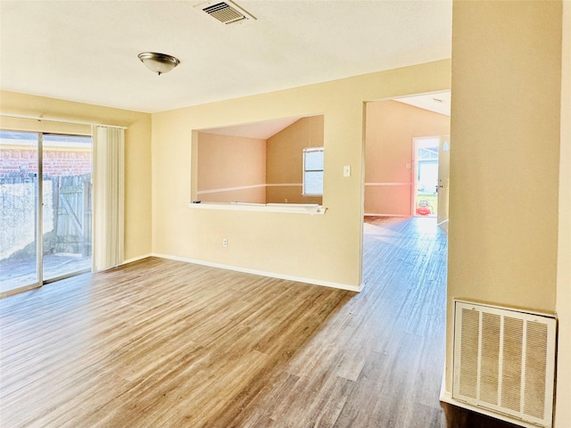 unfurnished room with wood-type flooring and vaulted ceiling