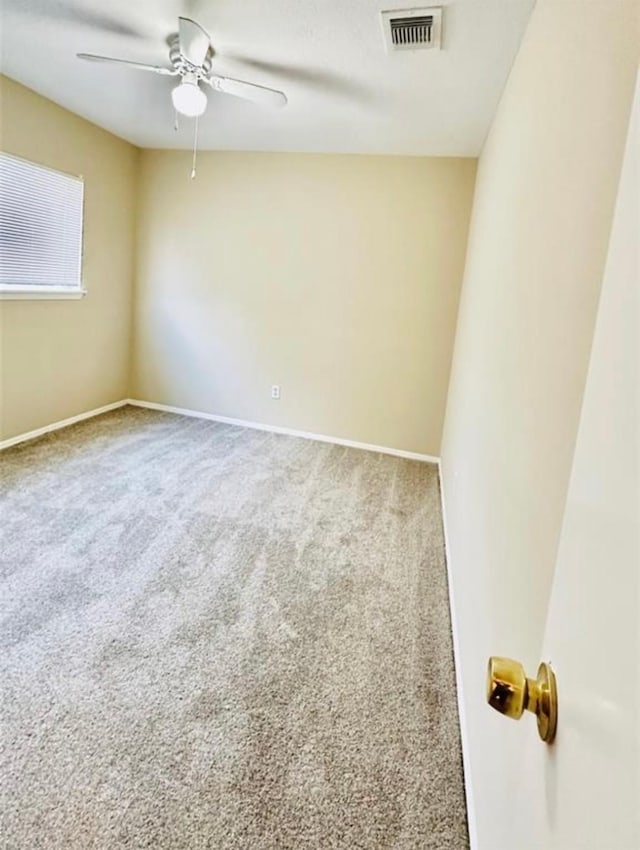 carpeted spare room with ceiling fan