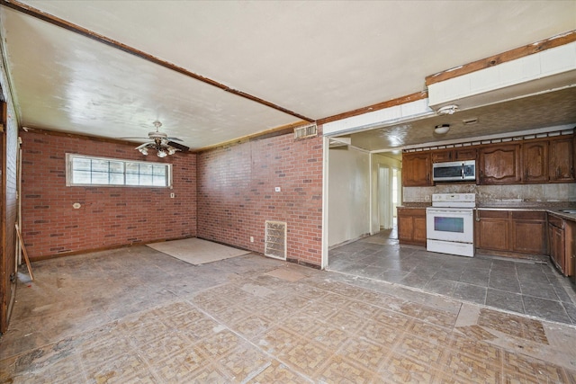 kitchen with tasteful backsplash, white range with electric stovetop, ceiling fan, and brick wall