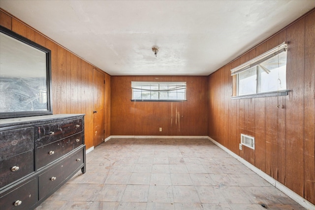 unfurnished room with a wealth of natural light and wooden walls