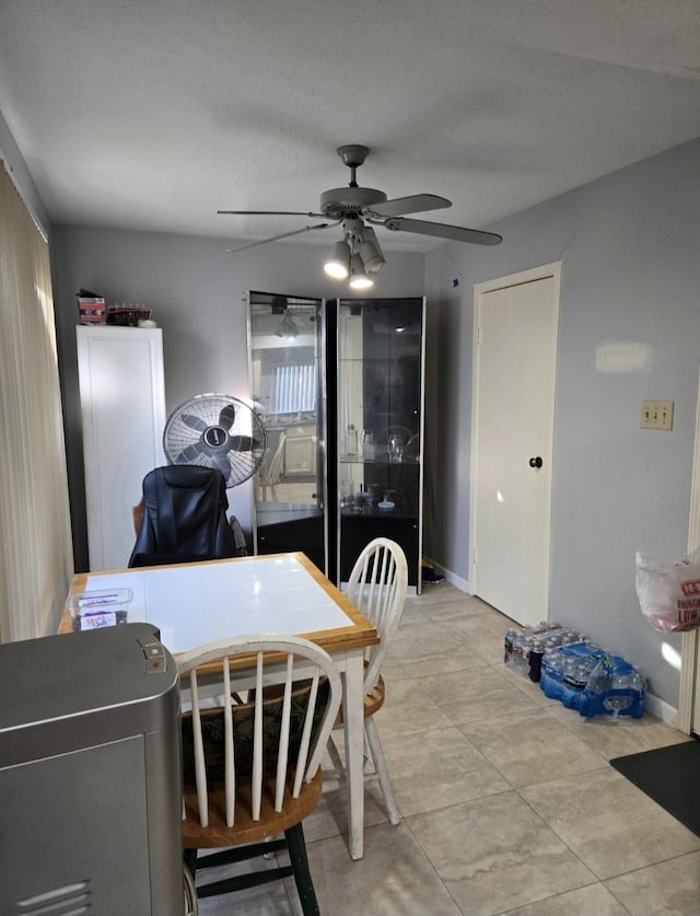 dining room with ceiling fan, light tile patterned floors, and a textured ceiling