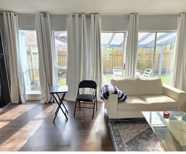 living room with plenty of natural light and dark wood-type flooring