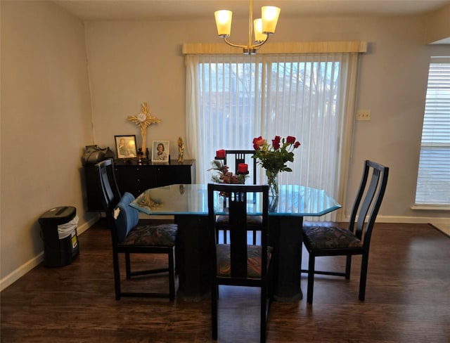 dining space with a notable chandelier and dark hardwood / wood-style floors