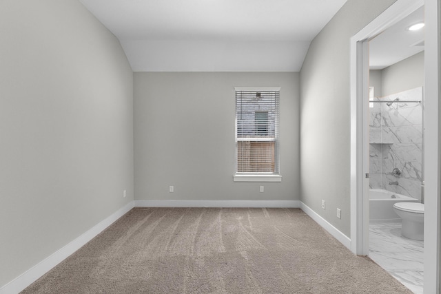 unfurnished room with carpet floors and vaulted ceiling