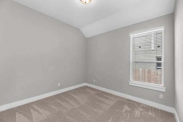 empty room with carpet flooring, plenty of natural light, and vaulted ceiling