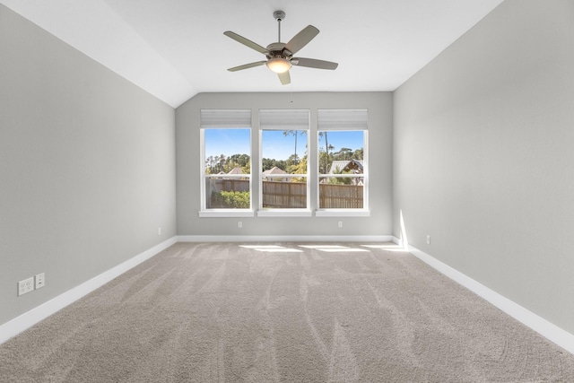 spare room with ceiling fan, carpet, and vaulted ceiling