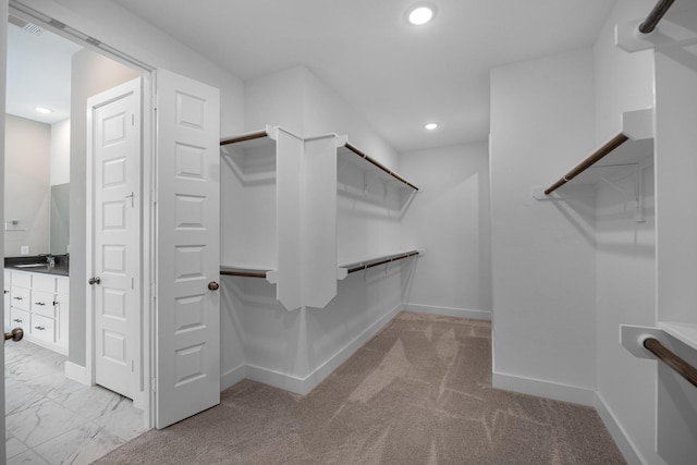 walk in closet featuring light carpet