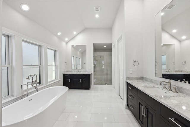 bathroom featuring vanity, independent shower and bath, and lofted ceiling