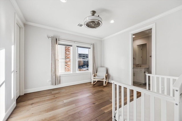 unfurnished bedroom with ensuite bath, crown molding, and light hardwood / wood-style flooring