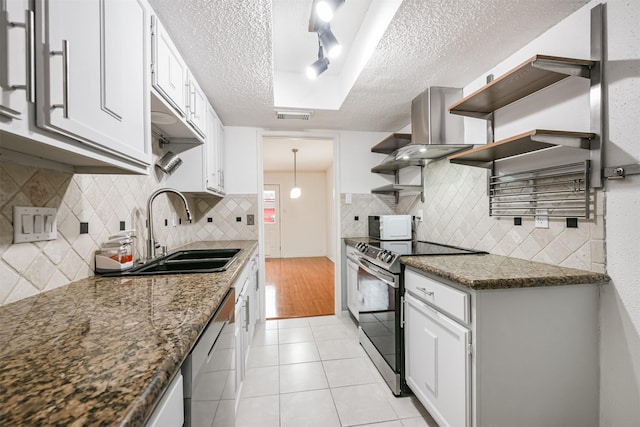 kitchen featuring appliances with stainless steel finishes, wall chimney exhaust hood, a textured ceiling, sink, and white cabinetry