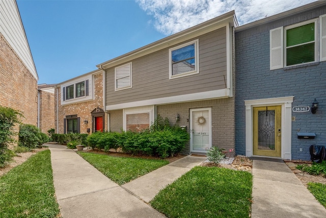 townhome / multi-family property with a front yard