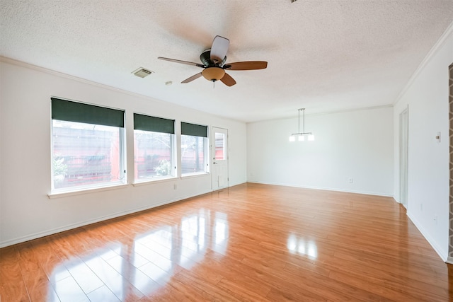 unfurnished room with ceiling fan, light hardwood / wood-style floors, crown molding, and a textured ceiling