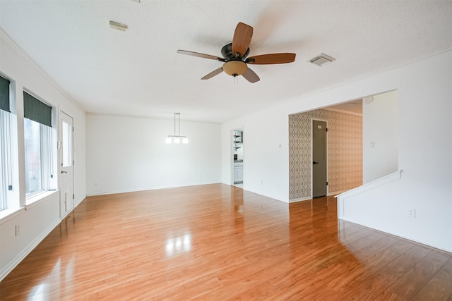 unfurnished room with ceiling fan, crown molding, light hardwood / wood-style floors, and a textured ceiling