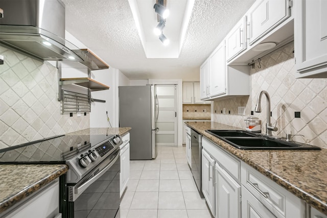 kitchen with dark stone counters, white cabinets, sink, a textured ceiling, and stainless steel appliances