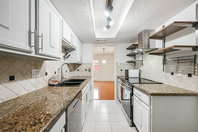 kitchen with track lighting, stainless steel appliances, sink, white cabinets, and light tile patterned flooring