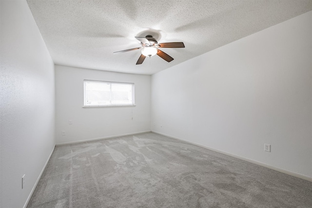 carpeted spare room with ceiling fan and a textured ceiling