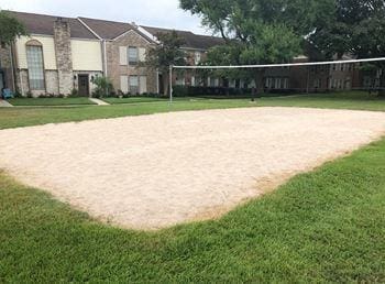 view of property's community with a lawn and volleyball court