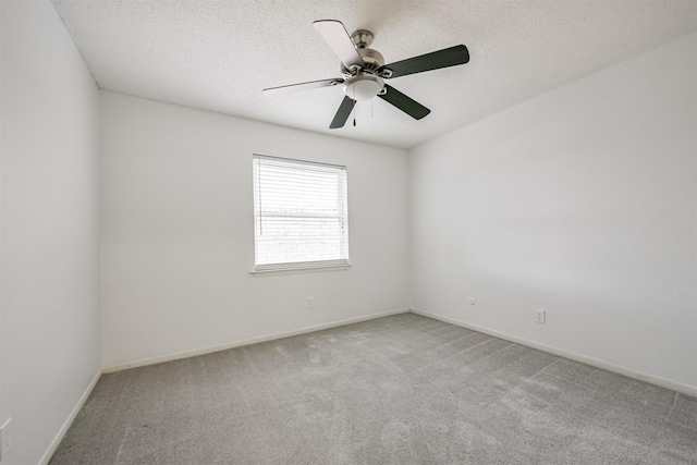 spare room with ceiling fan, light colored carpet, and a textured ceiling