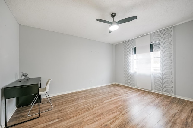 office area with ceiling fan, light hardwood / wood-style floors, and a textured ceiling