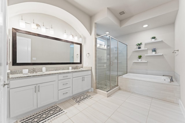 bathroom with plus walk in shower, tile patterned flooring, and vanity