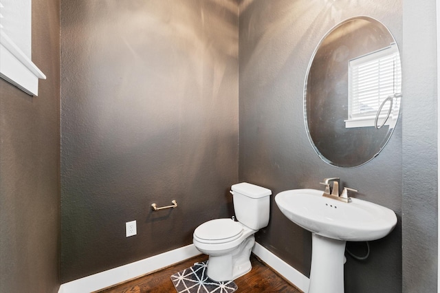 bathroom with hardwood / wood-style floors, toilet, and sink