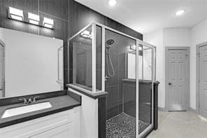 bathroom with a shower with door and vanity