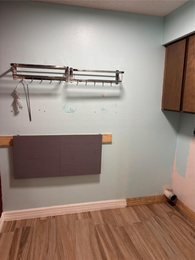 laundry area with wood-type flooring