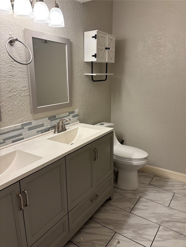 bathroom featuring vanity, tasteful backsplash, and toilet