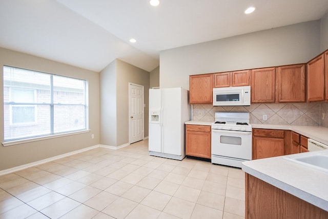 kitchen featuring decorative backsplash, light tile patterned flooring, white appliances, and lofted ceiling