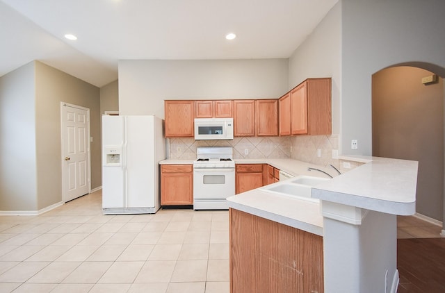 kitchen with kitchen peninsula, decorative backsplash, white appliances, sink, and light tile patterned floors