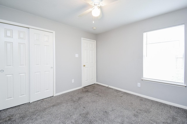 unfurnished bedroom with carpet, a closet, and ceiling fan