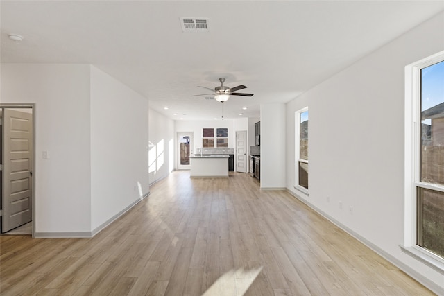 unfurnished living room featuring ceiling fan and light wood-type flooring