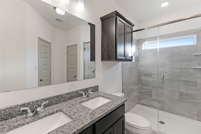 bathroom featuring an enclosed shower, vanity, and toilet