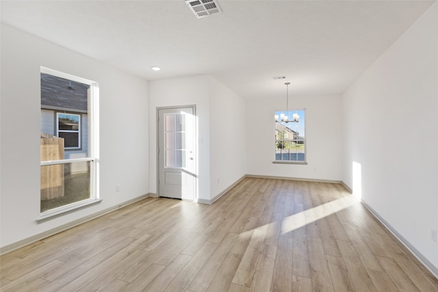 unfurnished dining area featuring a chandelier and light wood-type flooring