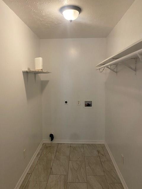 laundry area with electric dryer hookup, washer hookup, and a textured ceiling