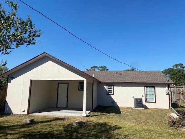 rear view of house with a yard, cooling unit, and a patio