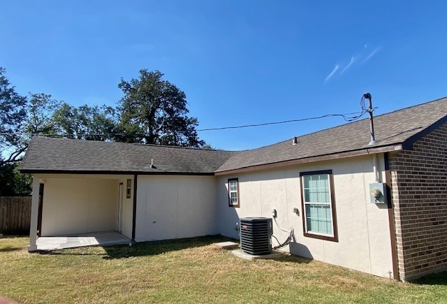 back of house featuring a lawn and central AC