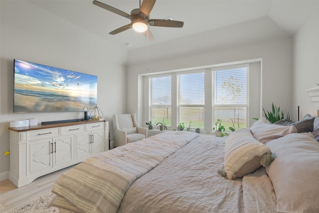 bedroom featuring ceiling fan, light hardwood / wood-style floors, and vaulted ceiling