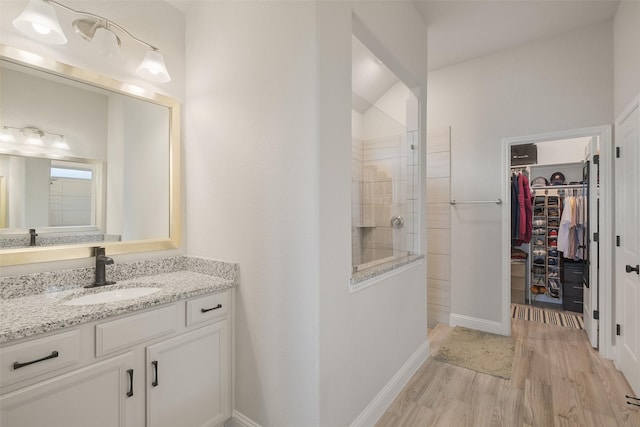 bathroom featuring a shower, wood-type flooring, and vanity