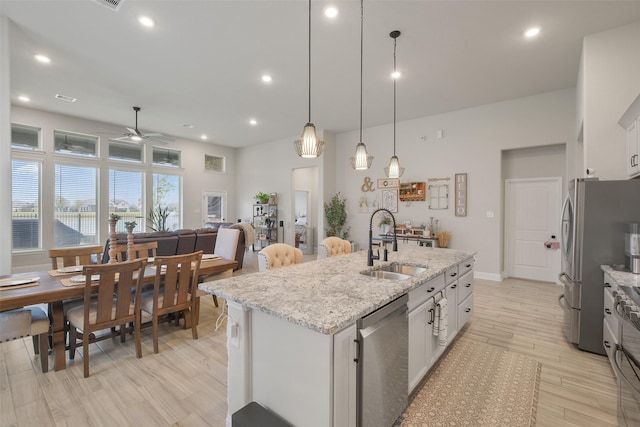 kitchen with ceiling fan, pendant lighting, white cabinets, and stainless steel appliances