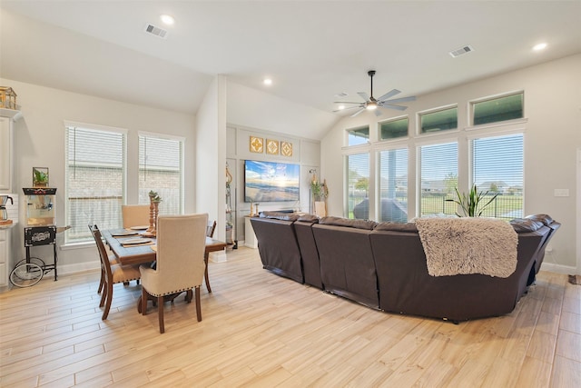 living room with ceiling fan, vaulted ceiling, plenty of natural light, and light hardwood / wood-style flooring